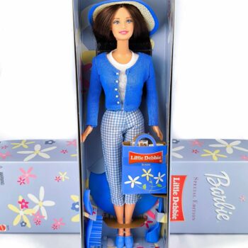 La Barbie Little Debbie Special Edition del 2001 è una bambola da collezione lanciata da Mattel in collaborazione con il marchio Little Debbie. Questa edizione speciale presenta Barbie con uno stile moderno che conserva il fascino classico dell’immagine originale di Little Debbie. Indossa una camicetta bianca con dettagli blu, pantaloni capri azzurri e una giacca blu con profili bianchi. Include accessori come borsa della spesa con logo Little Debbie, spazzola per capelli e supporto espositivo. È un pezzo apprezzato dai collezionisti per il legame con un marchio iconico della cultura pop americana.